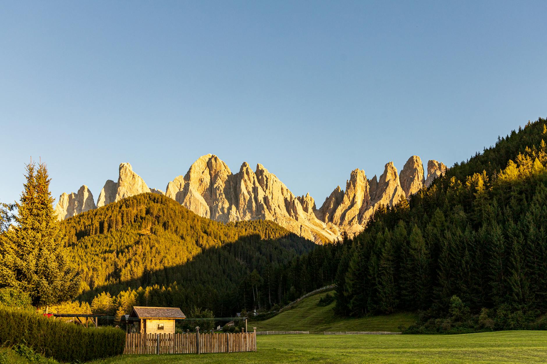 small house located in valley near green hills and mountains